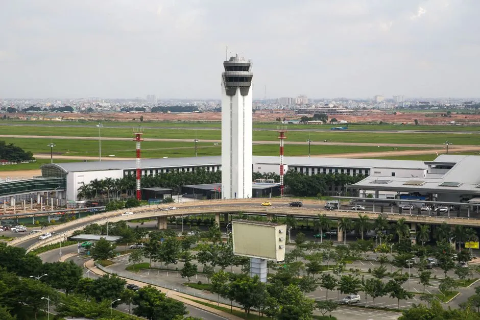 Aerial view of an airport with a control tower, runways and surrounding roads