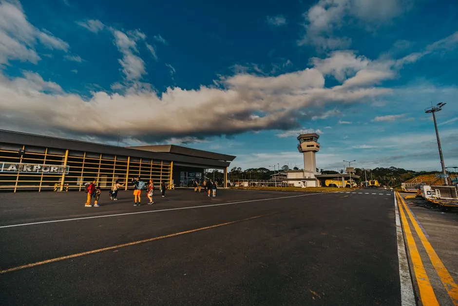 Small airport terminal with passengers walking across the tarmac